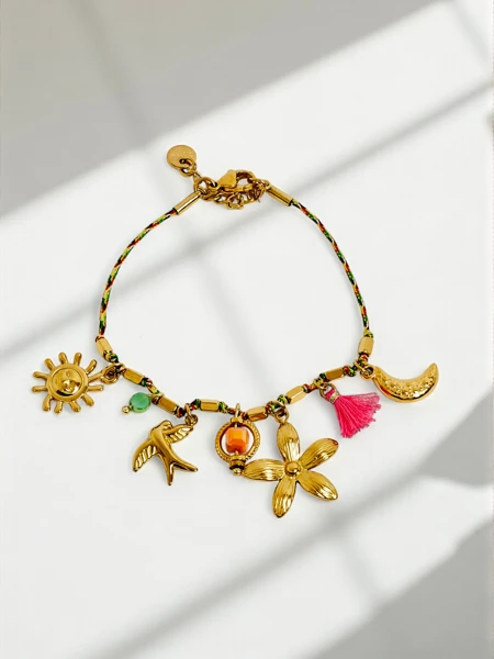 Callisto Bracelet with charms featuring a sun, bird and flower motif